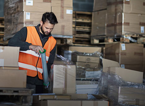 Warehouse employee wrapping a pallet of freight for shipping